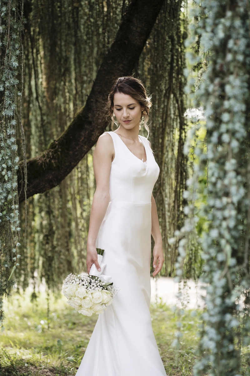 Abito da sposa in pizzo con mantella di tulle.