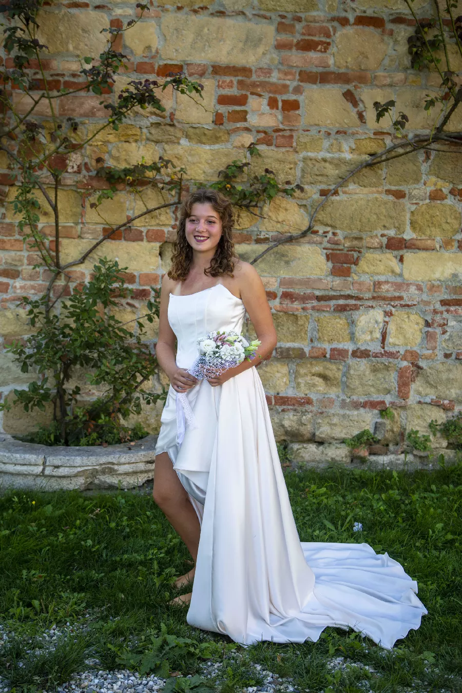 Chiusura con bottoni di perla e cintura ricamata Swarovski su abito da sposa elegante.